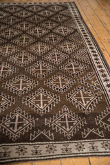 Distressed Oushak rug close-up shows starburst border and repeating serrated medallions.