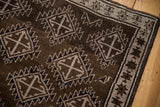 Distressed Oushak rug with softened chocolate brown field, serrated medallions, and starburst border.