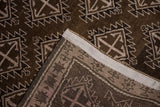 Vintage Distressed Oushak rug corner showing chocolate brown pile, serrated medallions, and original side selvage.