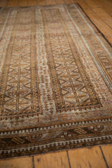 Luster of distressed vintage Belouch pile, geometric patterns in bronze and muted slate blue.