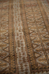 Geometric triangle pattern and worn pile texture on a vintage distressed Belouch rug.