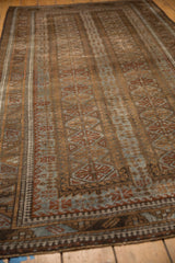 Visible wear on distressed Belouch rug, highlighting geometric guls in pale coffee bronze, slate blue.