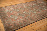 Vintage distressed Belouch rug, showing repeating rust guls and patterned main border.