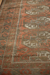 Worn pile of a Distressed Belouch rug, showcasing geometric patterns in rust and muted grey tones.