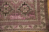 Distressed corner of the vintage Belouch runner, with purple geometric patterns and serrated leaf border.