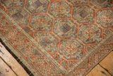 Distressed Belouch rug texture showing repeating lattice, floral motifs, madder red, and sky blue.