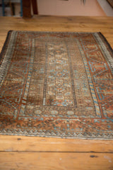 Distressed Belouch rug: floral guls, vine, wave motifs, coffee brown, rust, sky blue.