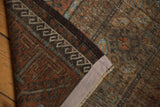 Vintage distressed Belouch rug, showcasing coffee brown pile texture and original side cord selvage.