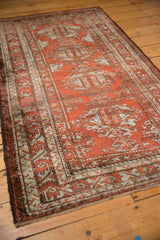 Distressed vintage Belouch rug's brick red field with slate silver borders and palmettes.