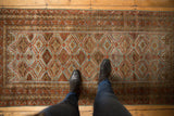 Distressed Belouch runner featuring geometric patterns in slate blue and rust.