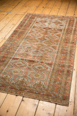 Distressed Belouch runner's lower corner, highlighting worn pile, faded blue and rust tones.