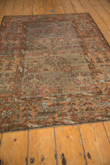 Distressed Belouch rug's geometric pattern, worn to knot heads, in muted terracotta and slate blue.
