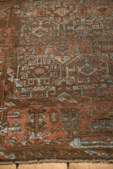 Distressed Belouch rug's hand-knotted pile with terracotta, rust, and slate blue geometric motifs.