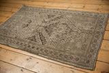 Vintage distressed Belouch rug corner with geometric border and rams horn motifs, showing even wear.