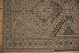 Lower left corner of distressed Belouch rug, featuring geometric borders and rams horn design.