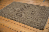 Distressed Belouch rug corner featuring geometric borders and texture.