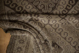 Distressed vintage Belouch rug texture with ram's horn motifs and soft wear.