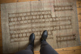 Distressed vintage Belouch rug detail showing geometric pattern in coffee brown and antique ivory.