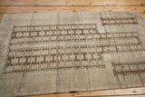 Distressed geometric patterns in coffee brown and antique ivory on a vintage Belouch rug.