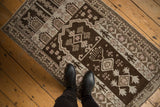 Distressed Belouch rug with hand and starburst motifs in chocolate brown, ivory.