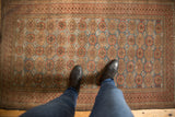 Vintage Distressed Belouch rug shows allover geometric floral pattern in dusty blue and madder root.
