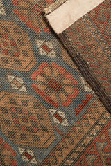 Distressed Belouch rug pile with visible knot heads, faint foundation, and woven side cord selvage.