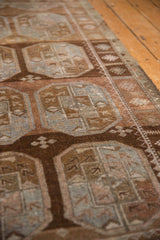 Detail of a vintage Belouch rug, showcasing worn gul motifs and abrashed brown texture.