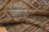 Folded vintage distressed Belouch runner texture, with abrashed browns, silver, and blush gul motifs.