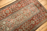 High-contrast geometric patterns in madder red and silver on a worn, lustrous vintage Belouch rug.