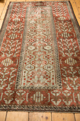 Long perspective on a vintage distressed Belouch rug showing its repeating panel design and wide borders.