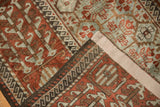 A folded corner of a vintage Persian rug reveals its secured side cord and lustrous, low wool pile.