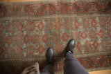 Distressed vintage Belouch runner with muted madder red and slate blue starbursts.