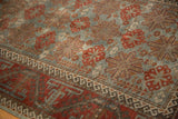 Distressed vintage Belouch runner, slate blue field with terracotta starbursts, and geometric border.