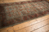 Distressed Belouch runner's corner showing geometric hook and latch border in terracotta and slate blue.