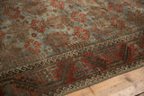 Distressed Belouch runner border: geometric hook-and-latch motif in slate blue and madder red.