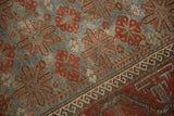 Distressed Belouch rug detail featuring slate blue field, madder red starbursts, hook border.
