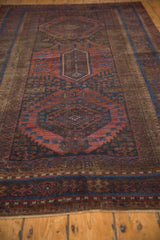Distressed texture and sapphire blue, madder red geometric patterns on an antique Belouch rug.