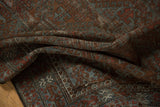 Distressed Belouch rug pile with worn knot heads, chestnut, slate blue, brick red.