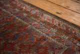 Worn pile texture of a distressed Belouch rug, with serrated cherry red and sapphire floral guls.