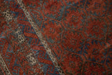 Distressed ruby red, sapphire blue Belouch pile with serrated floral guls and wave border.