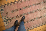 Distressed vintage Belouch rug pile, dusty rose abrash with floral gul medallions.
