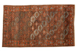 Distressed vintage Belouch rug, geometric guls in madder red, charcoal, and faded blue.