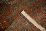 Distressed Belouch rug pile and folded back showing geometric pattern, madder red, and side selvage.