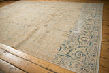 Distressed Kashan carpet corner, ivory field with navy blue scrolling arabesque border.