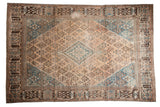 Distressed vintage Joshegan carpet, sky blue medallion, beige field with garden motifs.