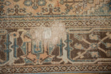 Textured detail of distressed Joshegan carpet, with visible foundation amidst muted patterns.