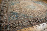 Distressed Joshegan rug corner, with worn sky blue, beige, and coffee brown geometric motifs.