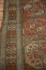 Worn texture of a distressed Belouch runner with blush Bokhara guls and blue rams horn.