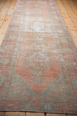 Distressed vintage Oushak runner pile, highlighting faded blush, rose, and seafoam floral designs.