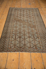 Vintage distressed Belouch runner displaying faded geometric lattice, worn pile, pale blue and chestnut.